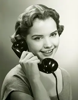 On The Phone Prints: Young woman talking on phone in studio, (B&W), portrait