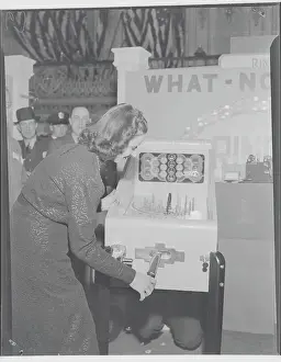 Young Woman Testing Coin Machinery for Game at Exhibit