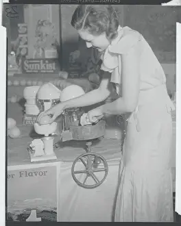 Young Woman Using Early Orange Juice Machine