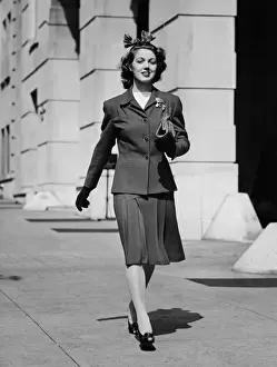 Strolling Prints: Young woman walking on sidewalk, (B&W)