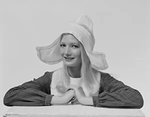 Young woman wearing dress hat, smiling, portrait