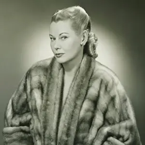 Bracelet Prints: Young woman wearing fur coat in studio, (B&W), portrait