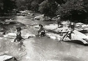 Young Women Sitting on Rocks in Creek
