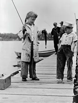 Youngster Displaying Catch on Dock