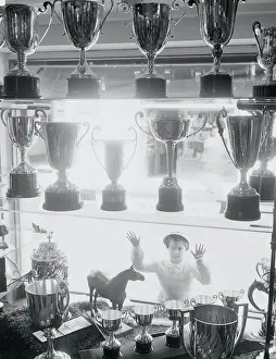 Youngster Gazing into Window at Trophies