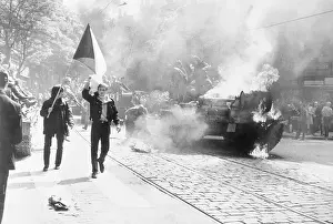 Youth Carry Flags Past Burning Tank