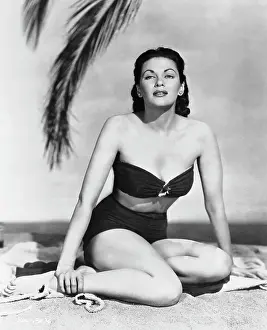 Yvonne De Carlo Sitting on Sandy Beach