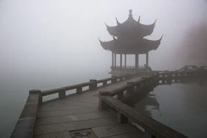 Images Dated 8th December 2015: A zig zag bridge and a Pavilion on the West Lake in foggy morning, Hangzhou